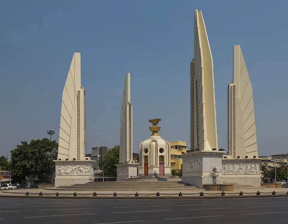 Monumento a la Democracia de Bangkok, con cuatro alas color crema alrededor de una torrecilla