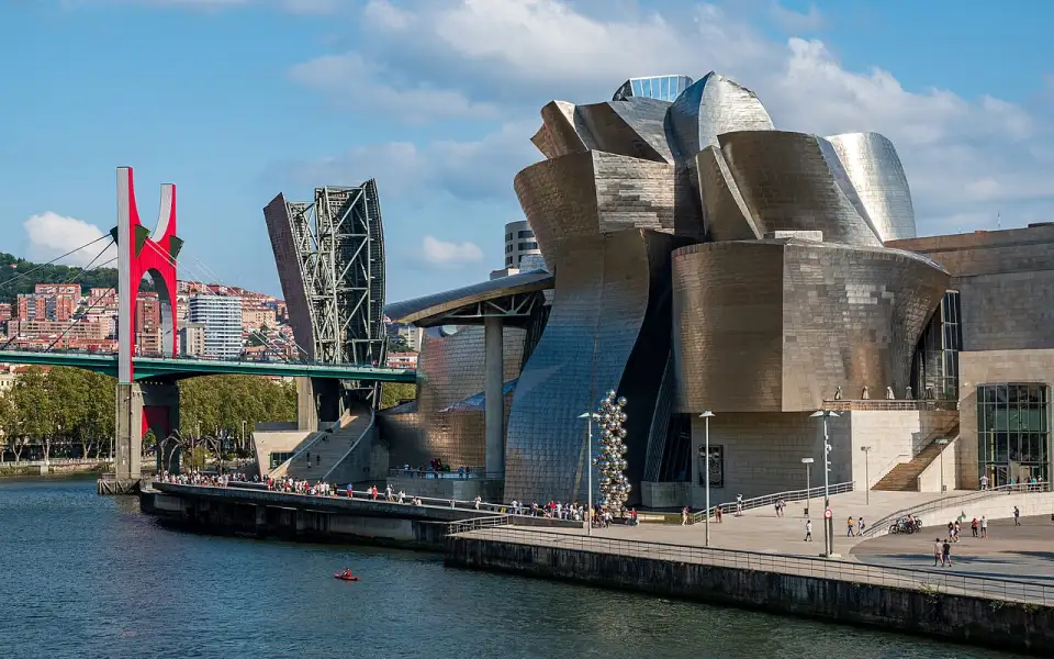 Das Guggenheim-Museum Bilbao am Fluss, links die La-Salve-Brücke mit ihren roten Bögen