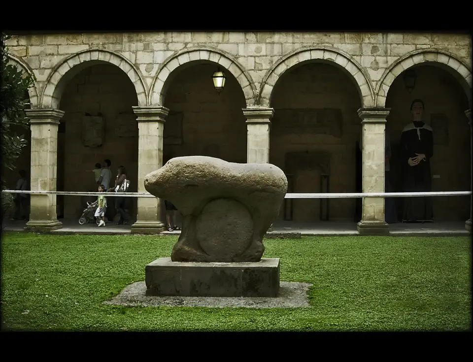 Ídolo de Mikeldi, escultura de pedra de um animal com um disco entre as patas, no claustro do Museu Basco