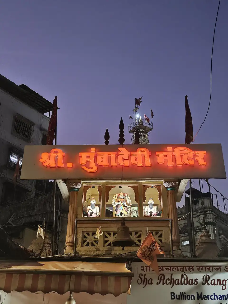 Leuchtend orangefarbenes Schild in Devanagari-Schrift über dem Eingang des Mumba-Devi-Tempels