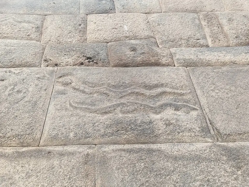 Serpentes esculpidas em relevo num bloco de pedra da rua Siete Culebras