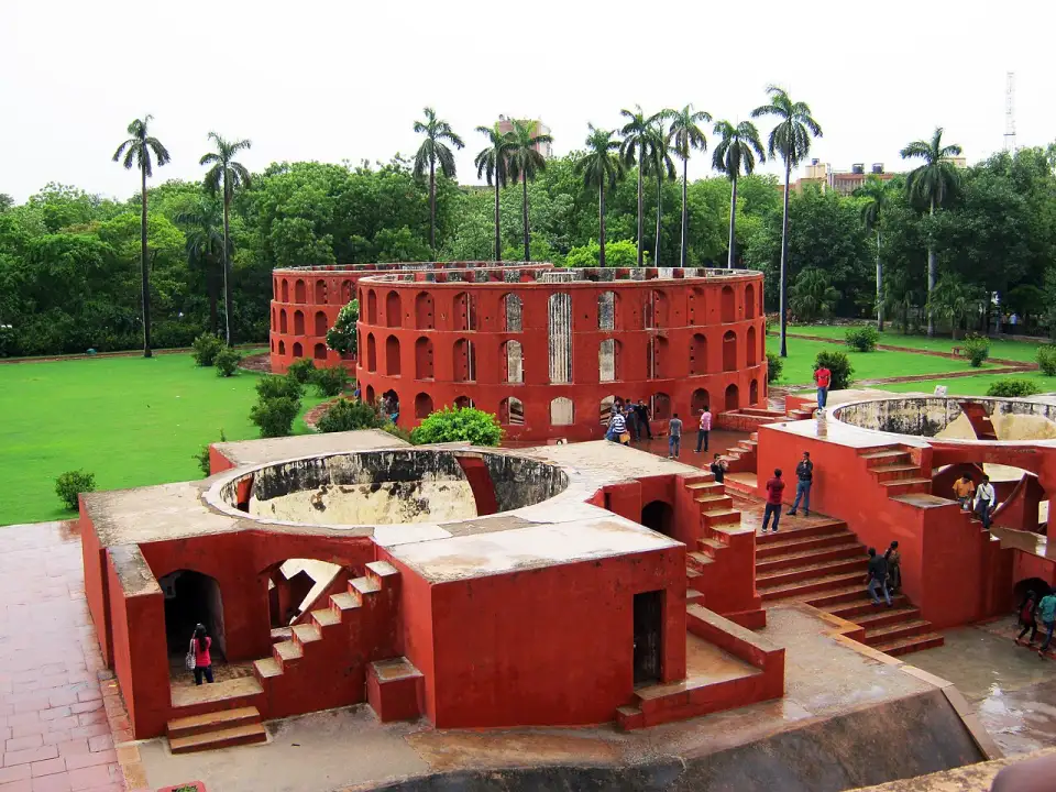 Instruments astronomiques rouges du Jantar Mantar parmi les palmiers