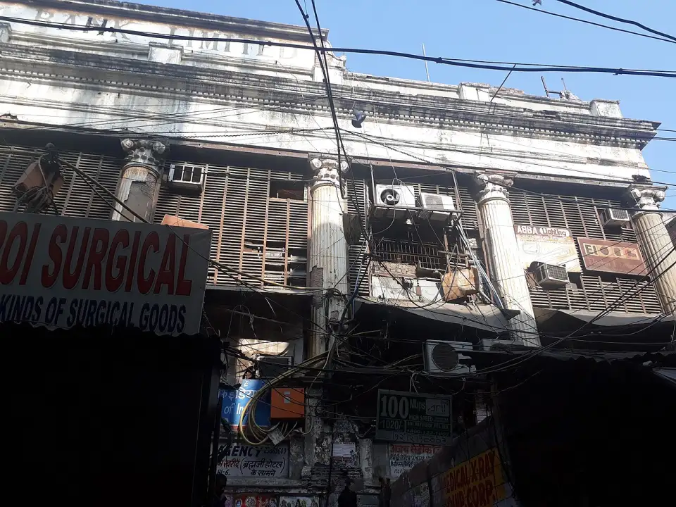 Fachada com colunas clássicas do palácio de Begum Samru coberta de letreiros