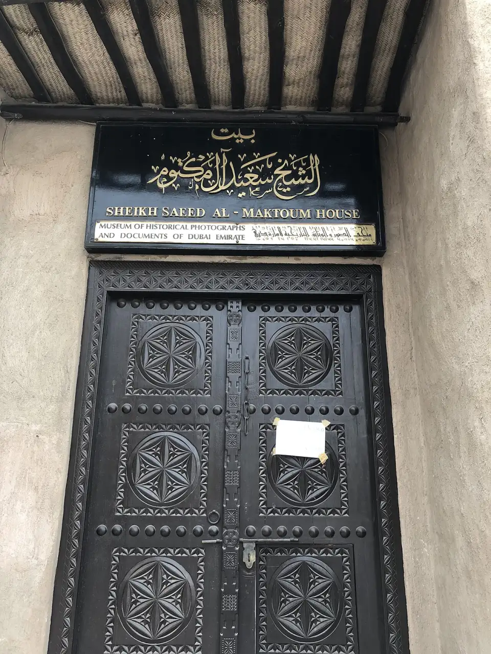 Puerta tallada de madera con el letrero de la casa del jeque Saeed Al Maktoum