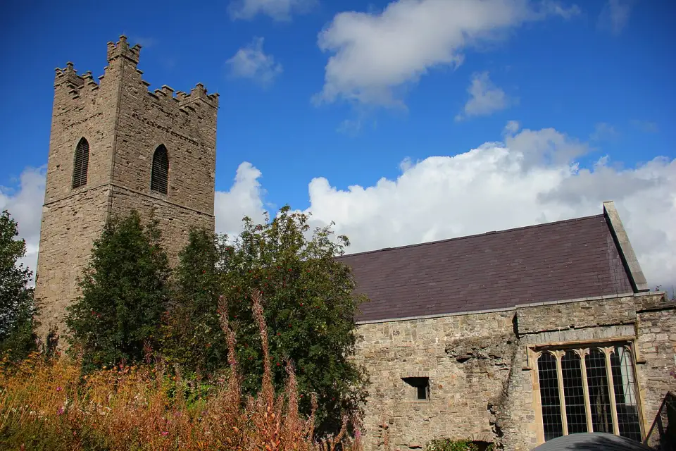 Zinnengekrönter Turm und steinernes Kirchenschiff von St Audoen's Church