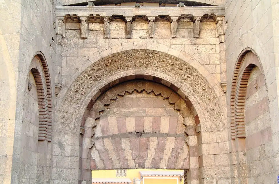 Arco de pedra decorada de Bab al-Futuh, o portão vizinho de torres arredondadas