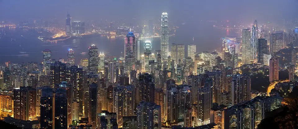 Nächtliches Panorama von Hongkong von oben, mit den beleuchteten Wolkenkratzern von Central und dem Victoria Harbour dahinter