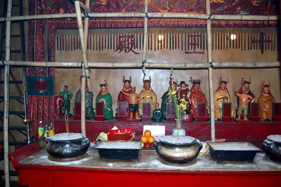 Altar im Man Mo Temple mit bemalten Götterfiguren, Räuchergefäßen und Opfergaben aus Orangen