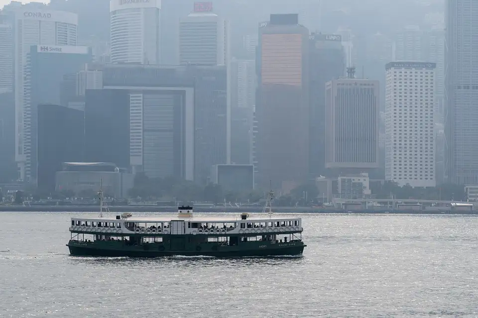 A green and white Star Ferry crossing Victoria Harbour with the island's skyscrapers behind