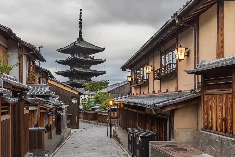 La pagoda de Yasaka al fondo de una calle empedrada con casas de madera y farolillos, al amanecer