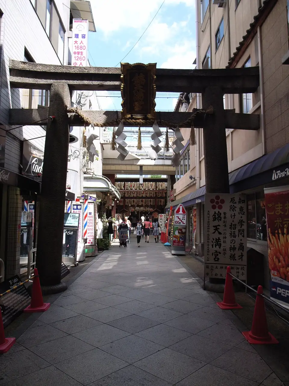 The stone torii of Nishiki Tenmangū, its ends buried in the neighbouring buildings