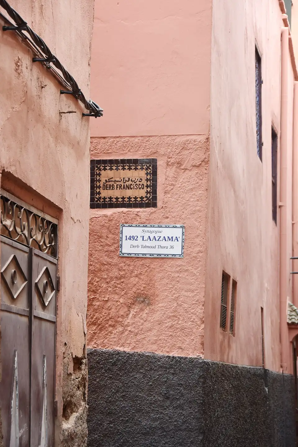 Ruelle rose du Mellah avec la plaque Derb Laazama