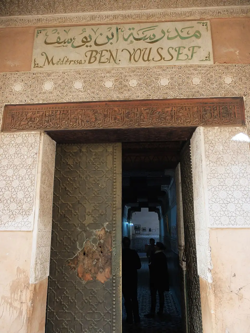 Bronze door of the Ben Youssef Madrasa with its sign