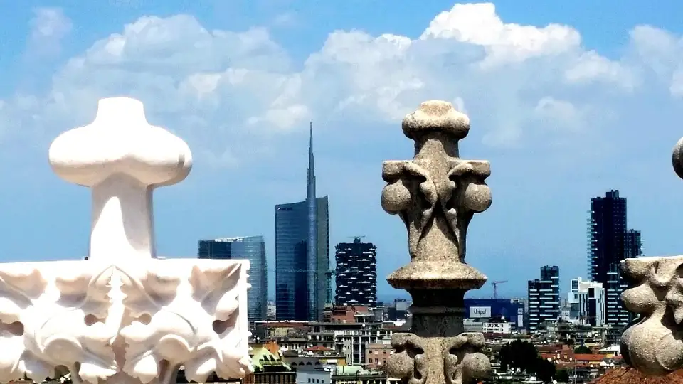 Marble spires of the Duomo in the foreground and the Porta Nuova skyscrapers behind