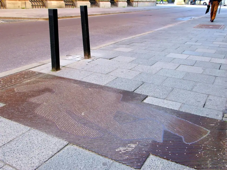 Metal plaque set into the pavement with the outline of a fallen body, the memorial to Kurt Eisner