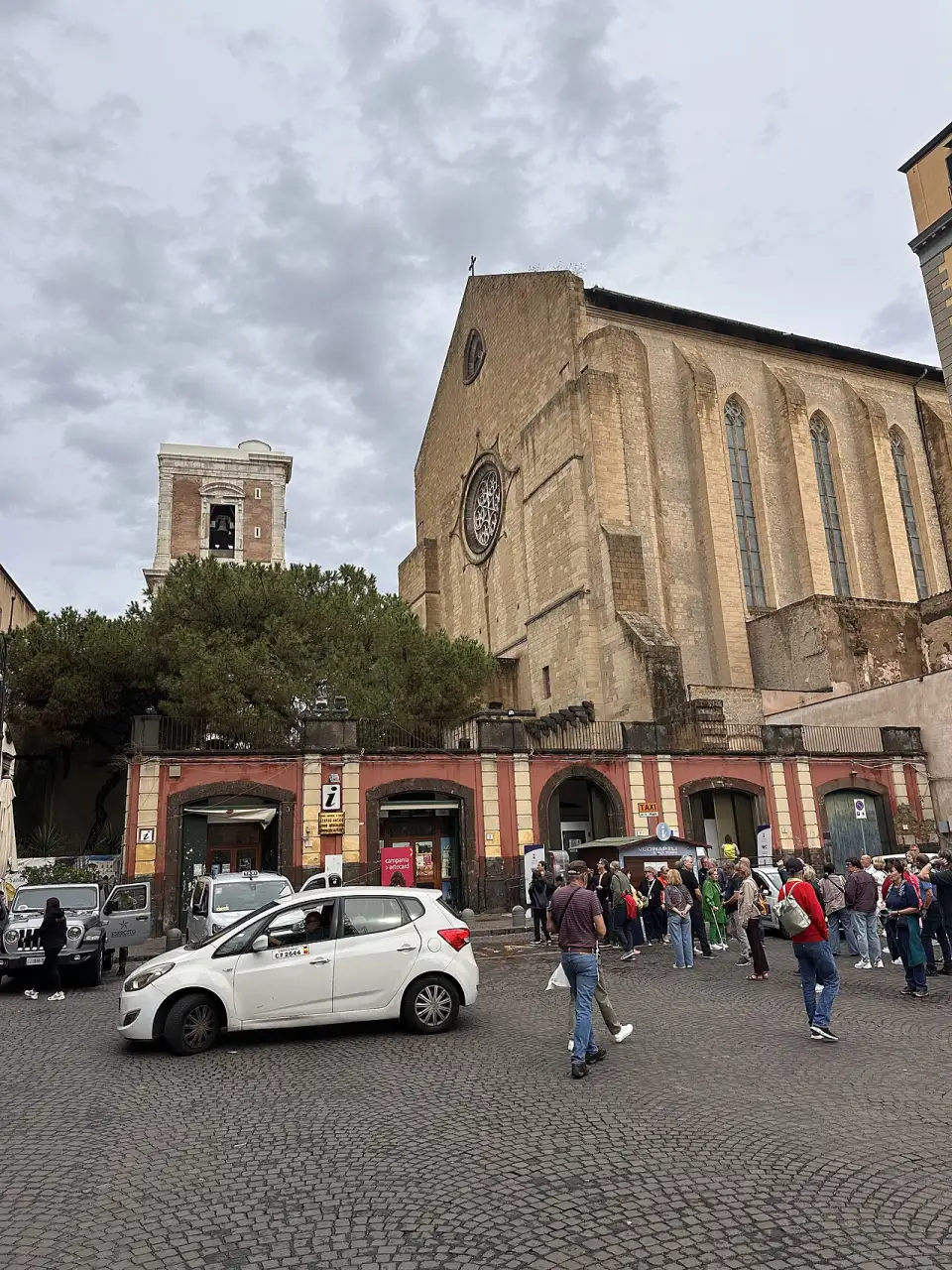 Die gotische Fassade von Santa Chiara mit Fensterrose und Glockenturm, vom Eingangstor aus gesehen