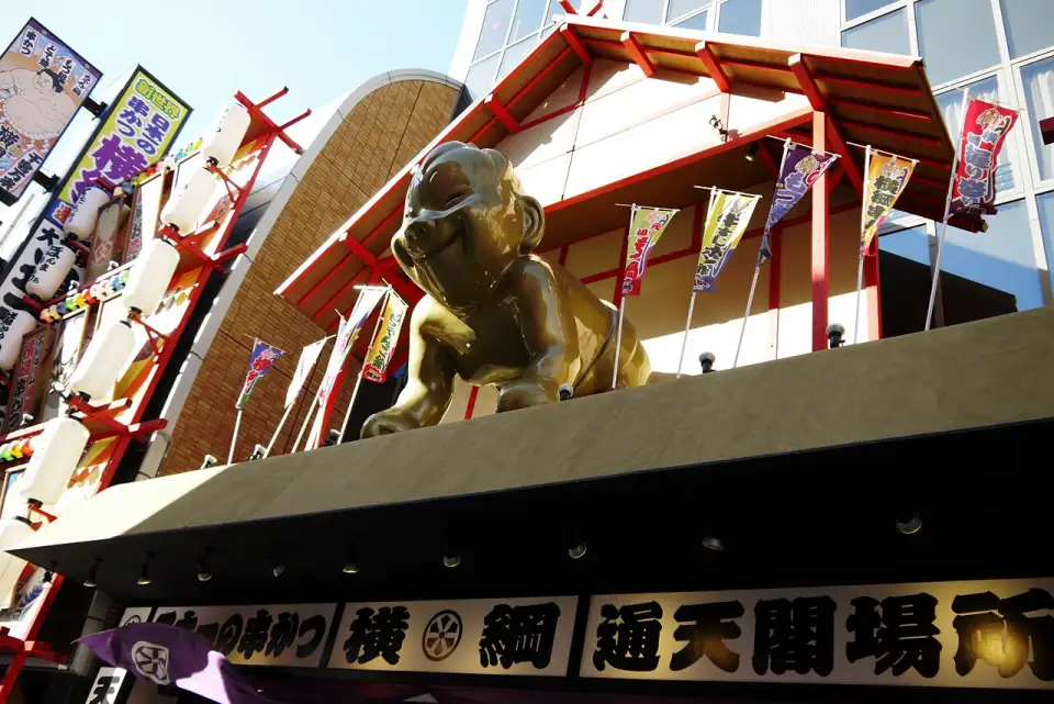 Gran figura dorada de Billiken sobre la fachada de un restaurante de Shinsekai