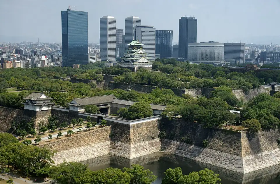 Osaka Castle among walls and moats, with the city's skyscrapers behind