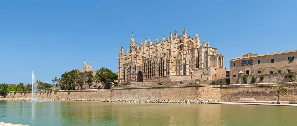 Palma Cathedral and the Almudaina Palace above the city walls, reflected in the lake of Parc de la Mar