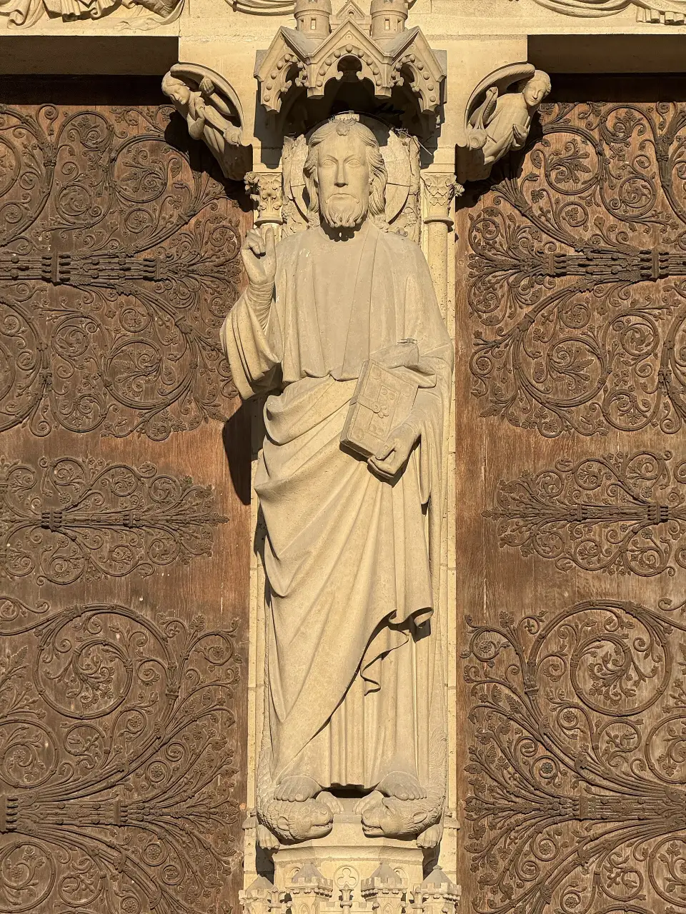 Pentures et statue du Christ au portail central de Notre-Dame