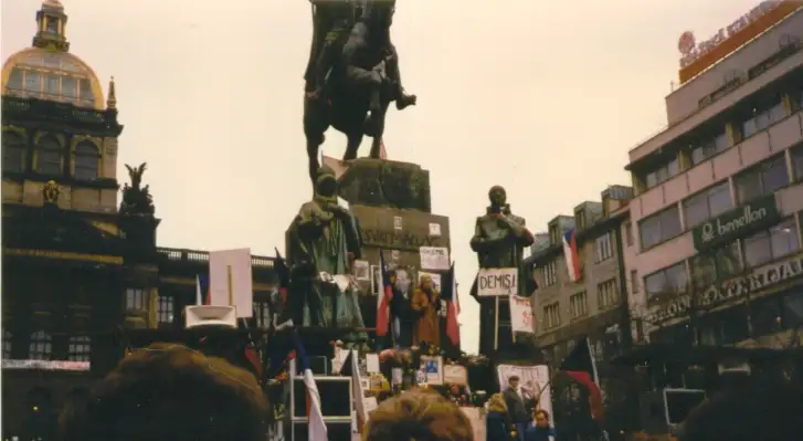 Multidão diante da estátua de São Venceslau em novembro de 1989, com bandeiras e cartazes