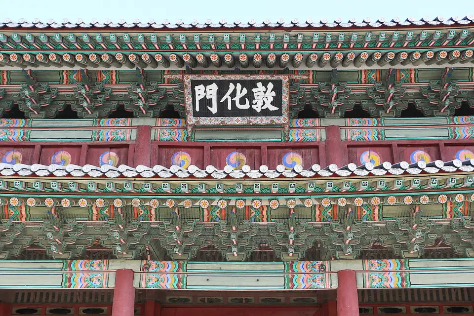 Détail de l'enseigne et des avant-toits peints de la porte Donhwamun