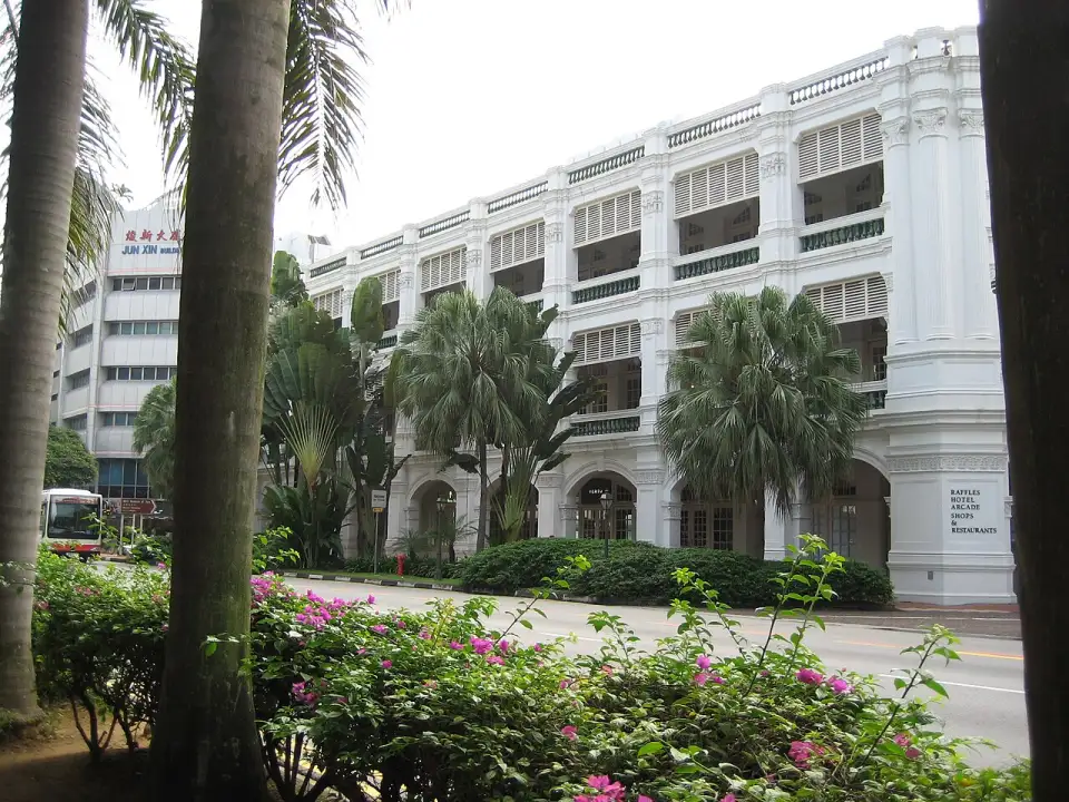 The white verandas of Raffles Hotel among palm trees