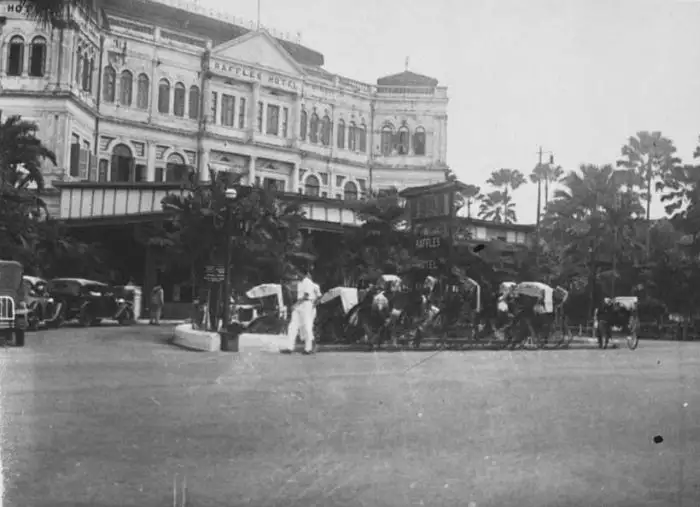 Old photograph of the Raffles Hotel entrance with rickshaws