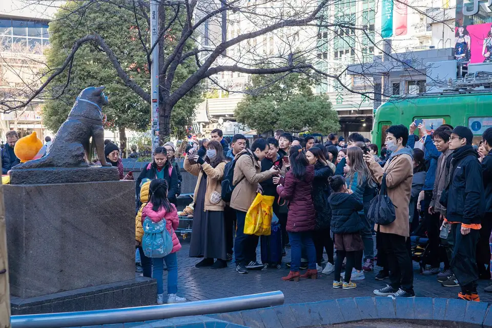 The bronze statue of Hachikō surrounded by people in Shibuya