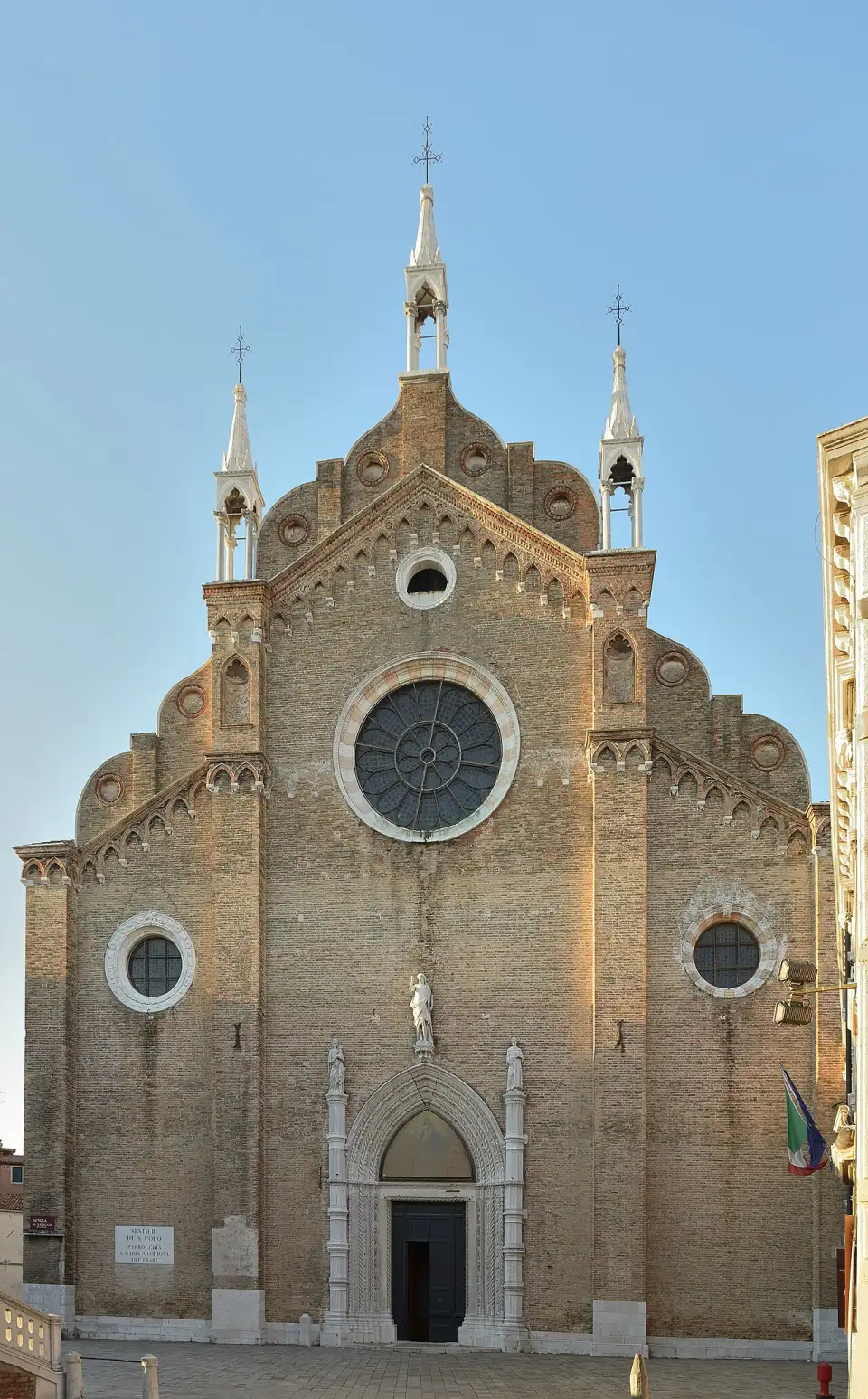 The Gothic brick facade of the Frari basilica with its pinnacles
